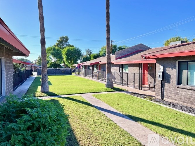 A row of houses with a green lawn in front.