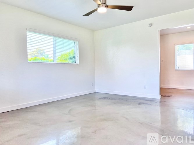 A room with a ceiling fan and a window with blinds.