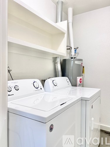 A white washing machine and dryer in a small laundry room.