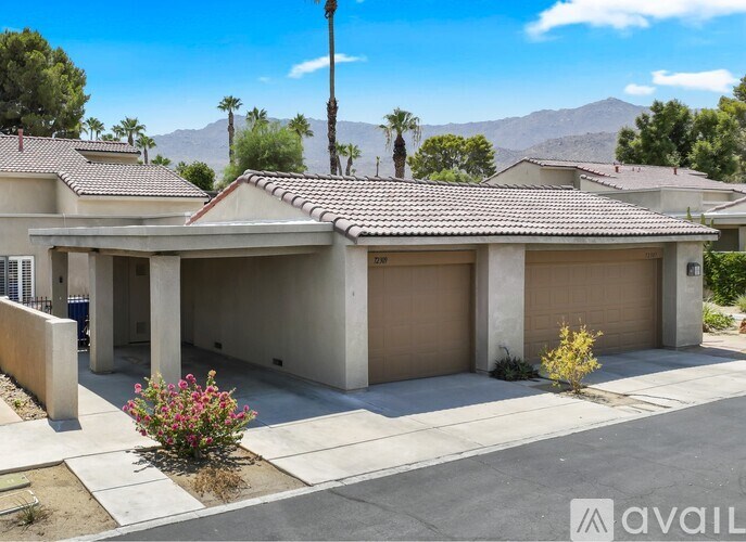 A house with a brown roof and beige garage doors is for sale.