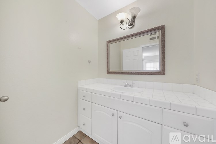 A white bathroom vanity with a mirror above it.