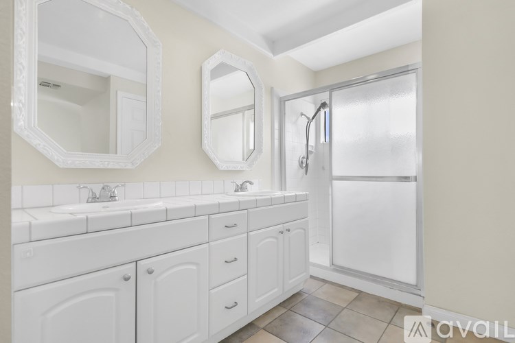 A bathroom with a white vanity and a walk-in shower.