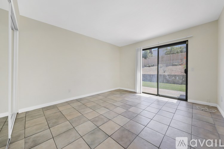 Empty room with tiled floor and sliding glass door.