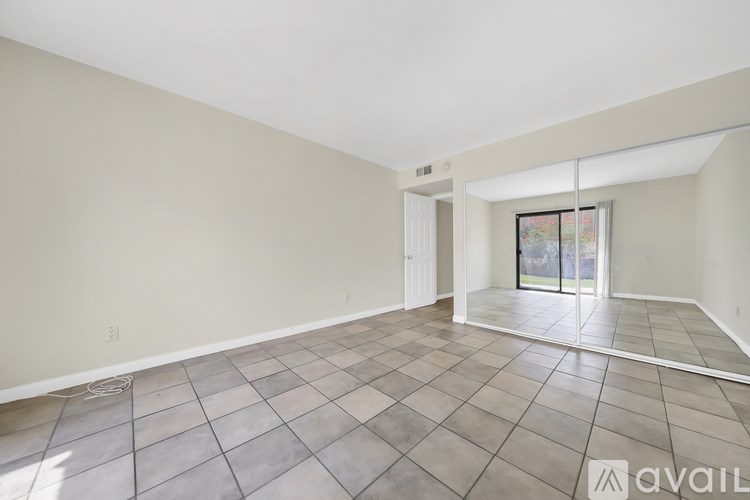 A spacious room with tiled flooring and a large window.