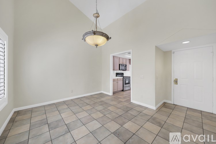 A room with a tiled floor and a chandelier hanging from the ceiling.