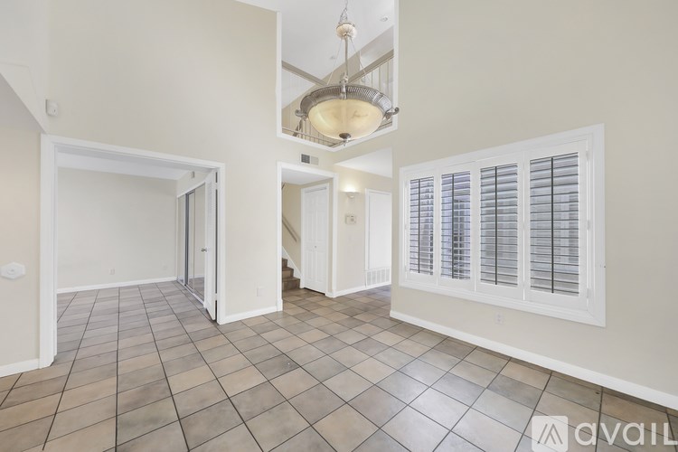 A room with tiled flooring and a chandelier hanging from the ceiling.
