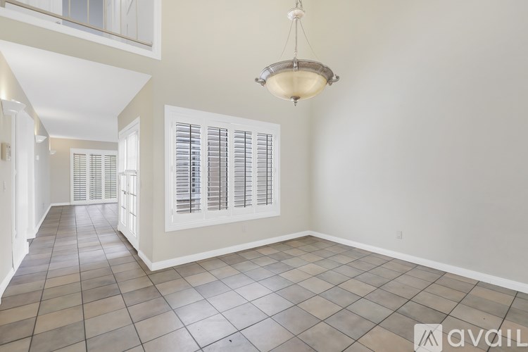 A room with tiled flooring and a chandelier hanging from the ceiling.