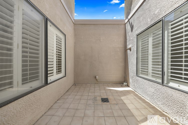 A sunny day in a small, empty room with tiled floors and walls.