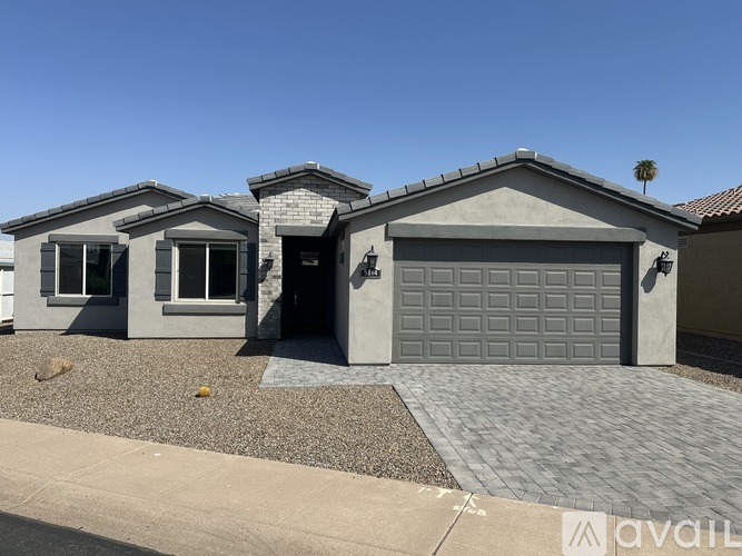 A house with a grey garage door is for sale.