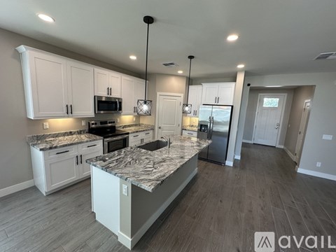 A kitchen with a granite countertop and white cabinets.