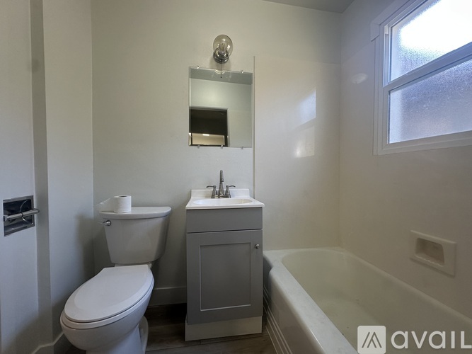 A bathroom with a toilet, sink, and bathtub.