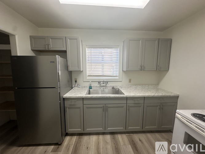 A kitchen with a stainless steel refrigerator and cabinets.