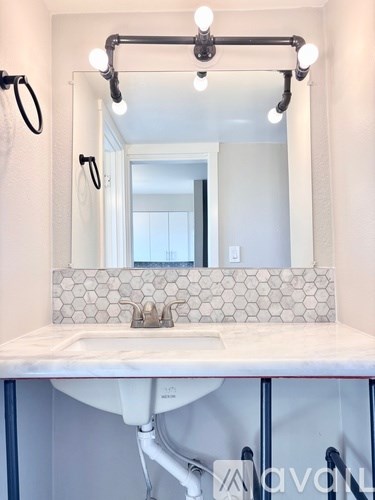 A bathroom with a white sink and a mirror above it.