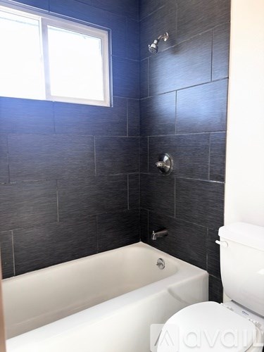 A bathroom with a white tub and toilet.