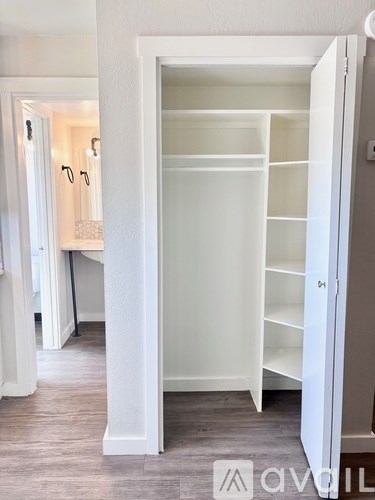A white closet with shelves is open in a room.