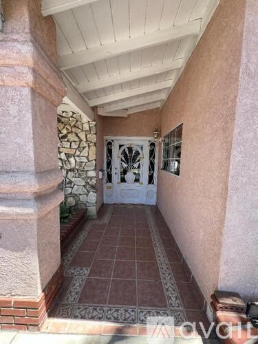 A white door is in a hallway with a tiled floor.