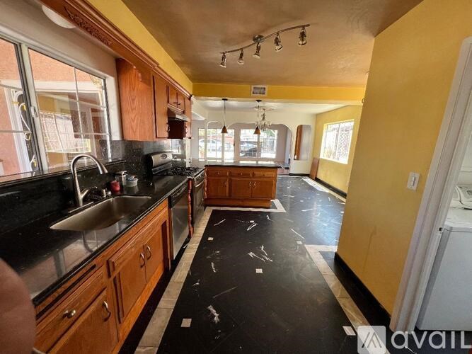 A kitchen with wooden cabinets and black countertops.