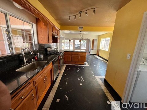 A kitchen with wooden cabinets and black countertops.