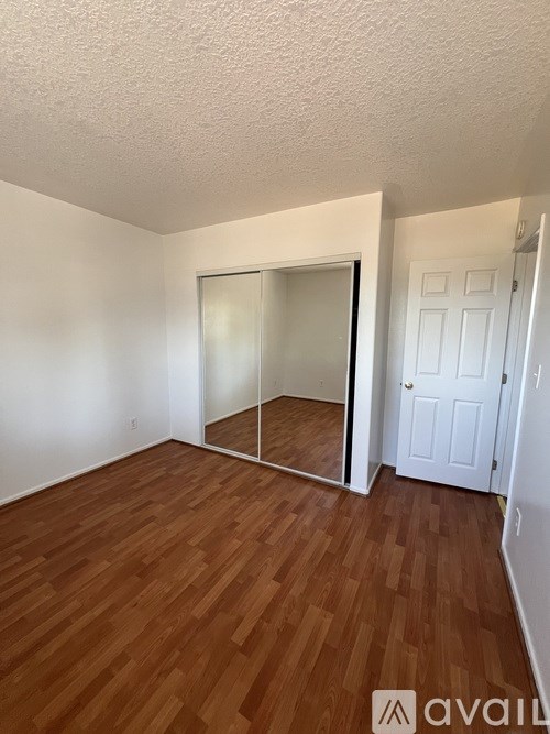 A room with wooden flooring and a white door.