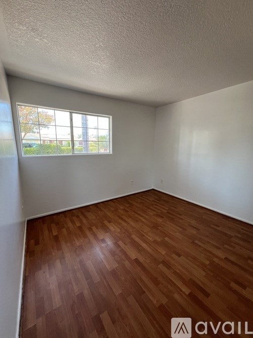 A room with wooden flooring and a window.