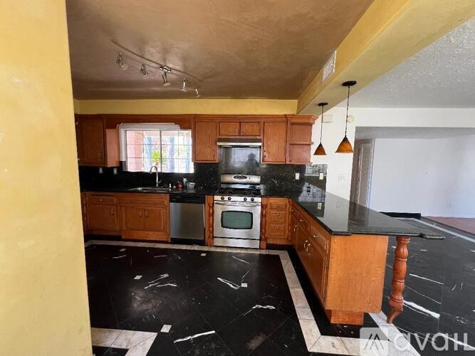A kitchen with black countertops and wooden cabinets.