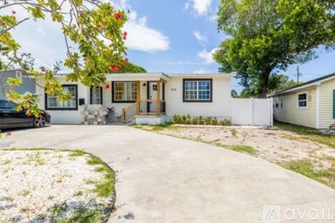 A house with a driveway and a car parked in front.