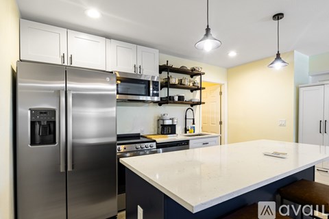 A modern kitchen with stainless steel appliances and a large island.