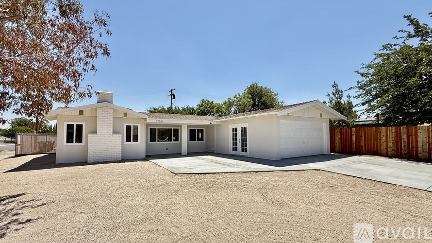 A modern house with a white exterior and a gravel driveway.