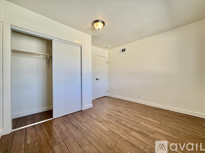 A room with a wooden floor and a white door.
