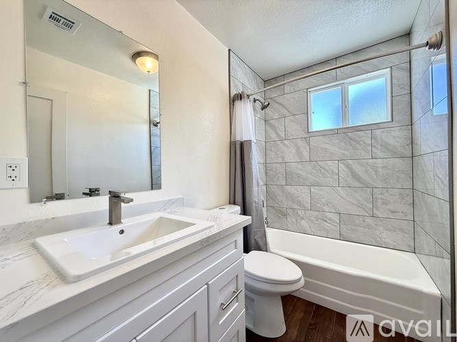 A bathroom with a white sink, toilet, and bathtub.