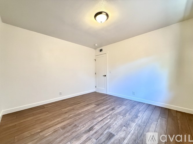A room with a wooden floor and a white door.