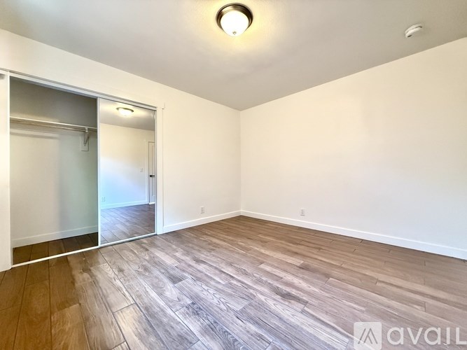 A room with wooden flooring and a sliding glass door.