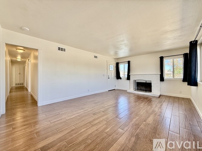 A spacious living room with hardwood floors and a fireplace.