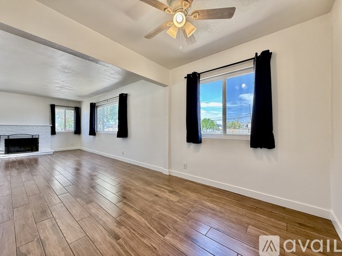 A room with a fireplace and a ceiling fan.