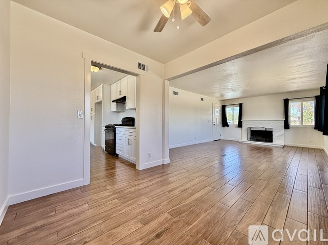 A living room with a fireplace and a ceiling fan.