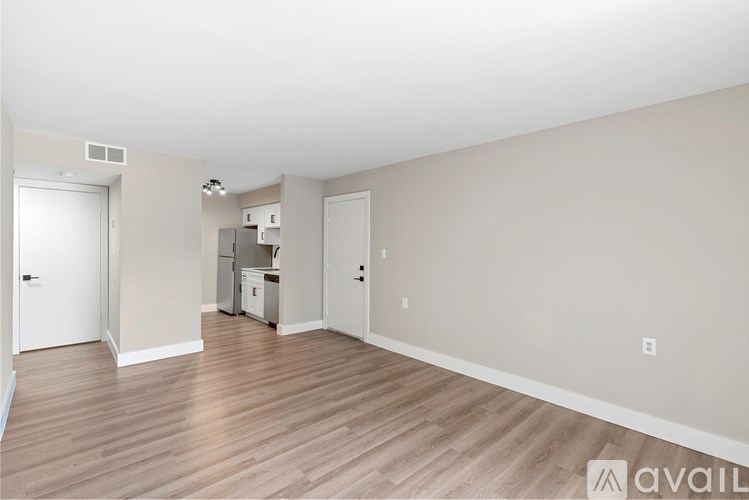 A spacious room with wooden flooring and white walls.