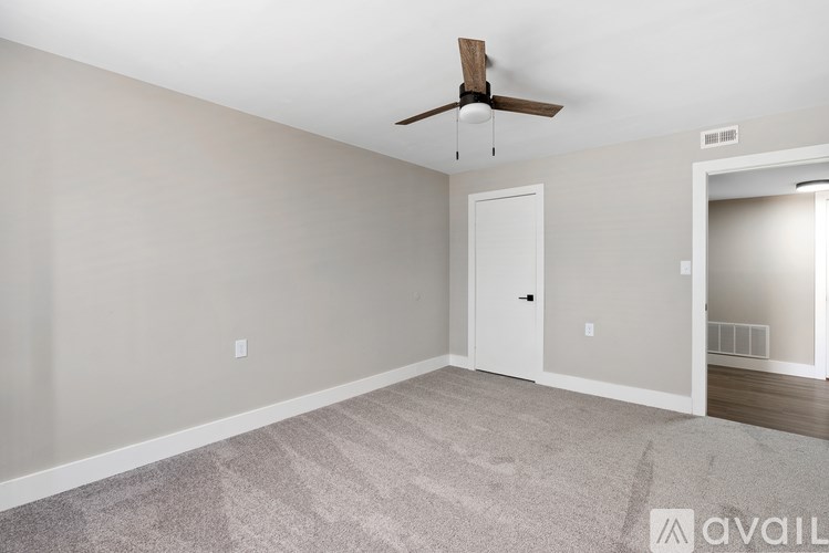 A room with a ceiling fan and a carpeted floor.