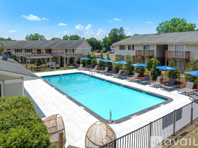 A large outdoor swimming pool surrounded by lounge chairs and umbrellas.
