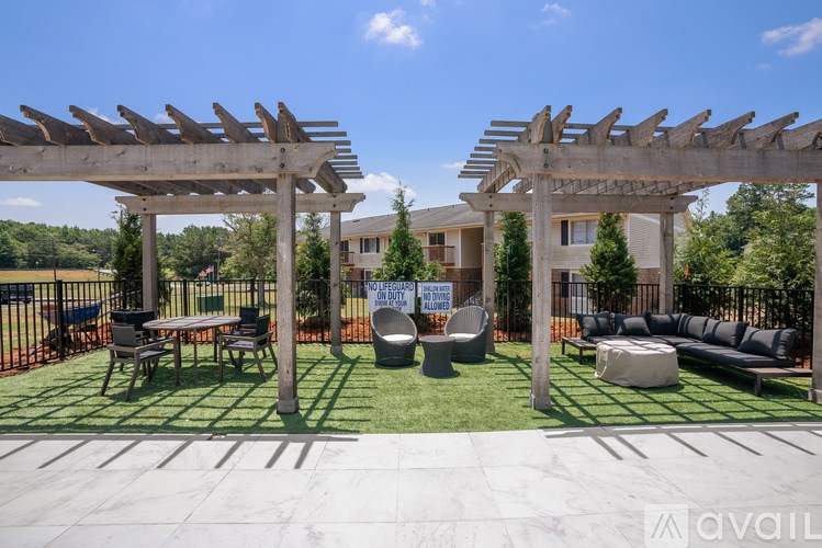 A patio with a pergola and seating area.