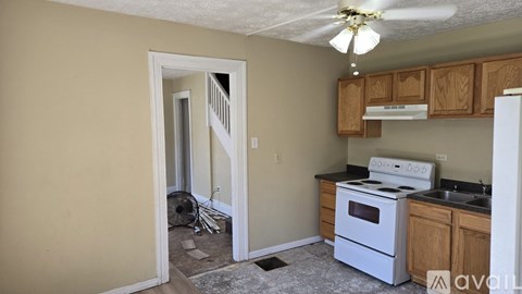 A kitchen with a white stove and wooden cabinets.