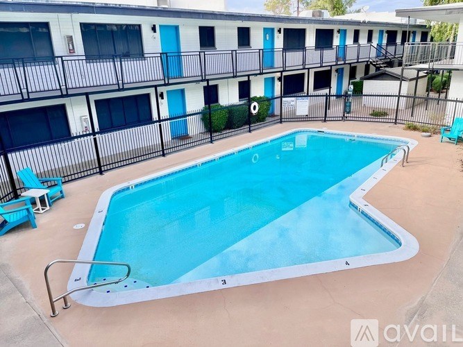 A swimming pool in front of a building with blue doors.