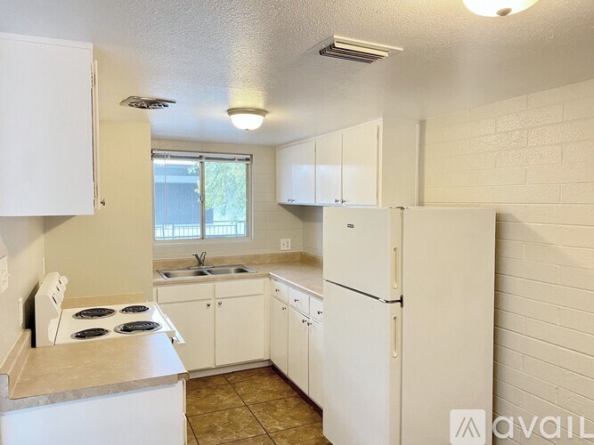 A kitchen with white appliances and cabinets.