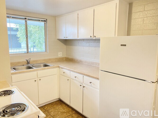 A kitchen with white appliances and cabinets.