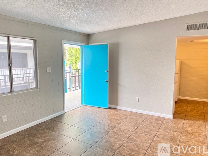 A room with a blue door and a tiled floor.