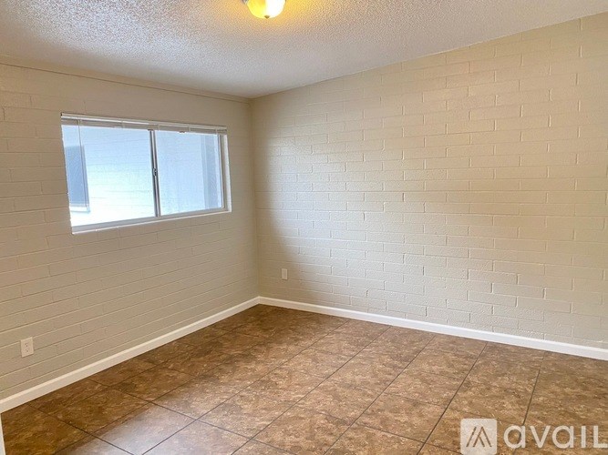 A room with a window and tiled floor.