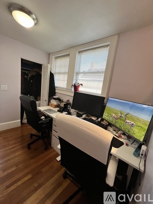 A room with a desk, chair, and computer monitor.