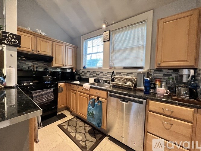 A kitchen with wooden cabinets and black countertops.