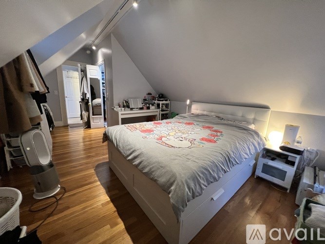 A bedroom with a large bed and a desk with a computer.