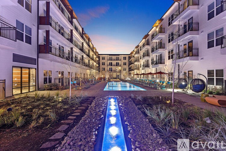 A modern apartment complex with a pool in the courtyard.