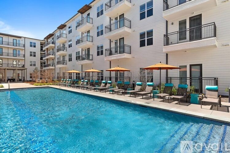 A swimming pool in front of a white apartment building.